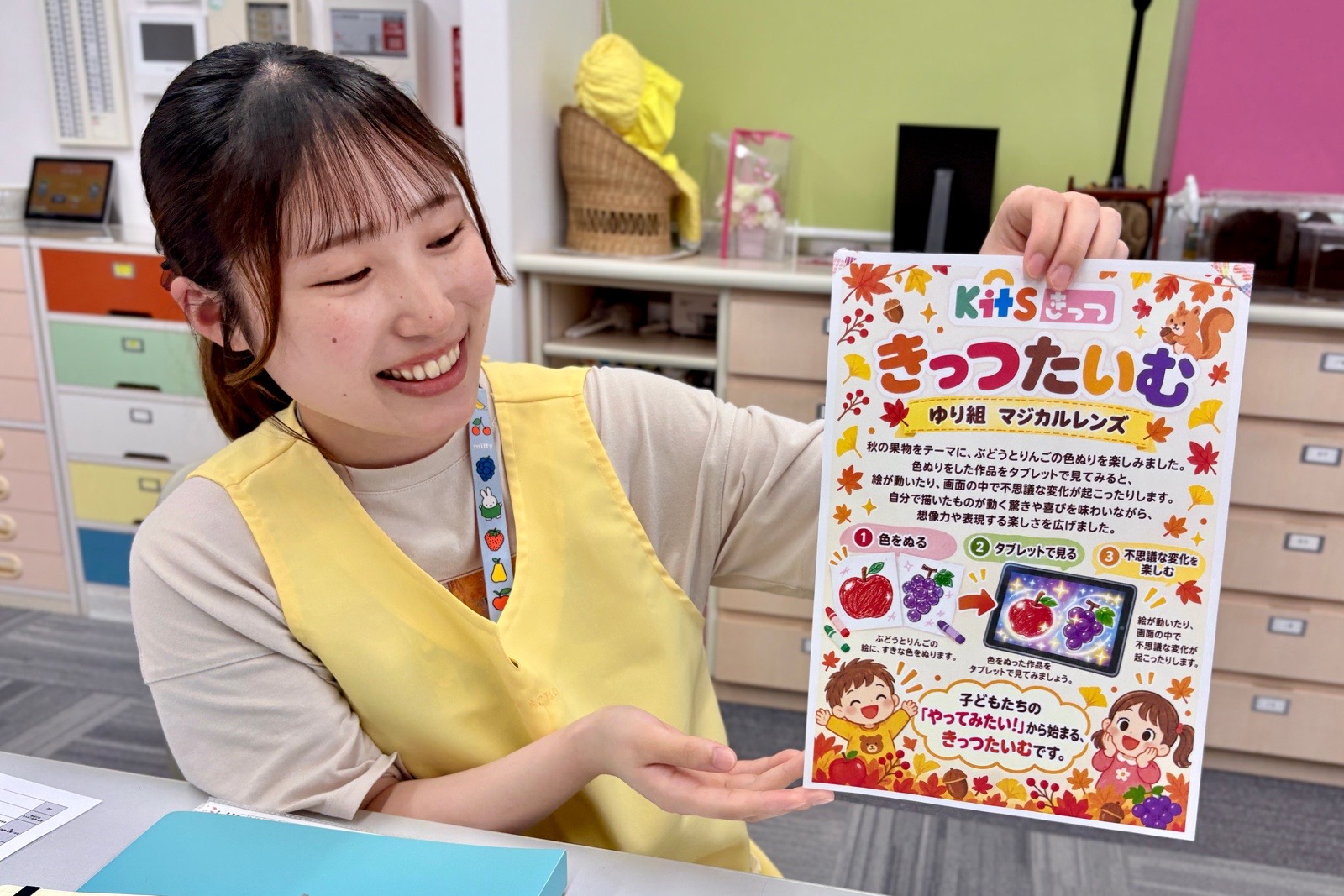 ヒナリーで作成した、タブレットを使った活動を紹介する保護者向けポスターを持つ影山先生
