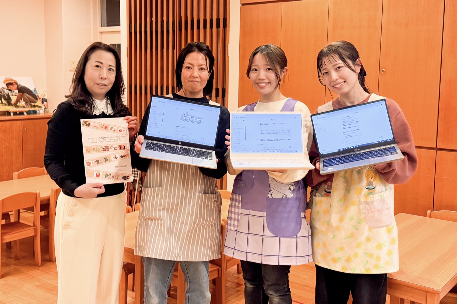 ヒナリーの画面を表示したノートパソコンを持つ、さくらぎ保育園の園長と先生方