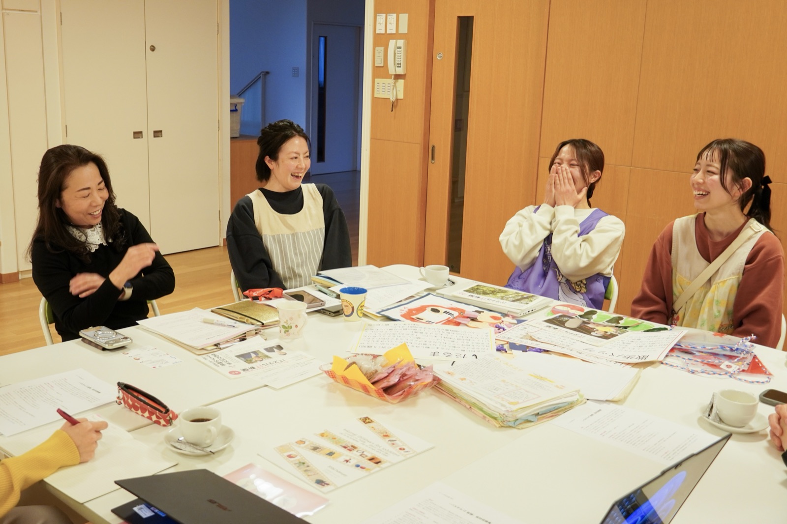 さくらぎ保育園の園長・副主任・担任の先生方が、机を囲んで笑いながら語り合っている様子
